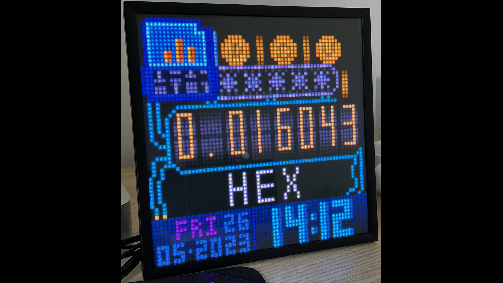 A pixelated colour display showing time date and other information